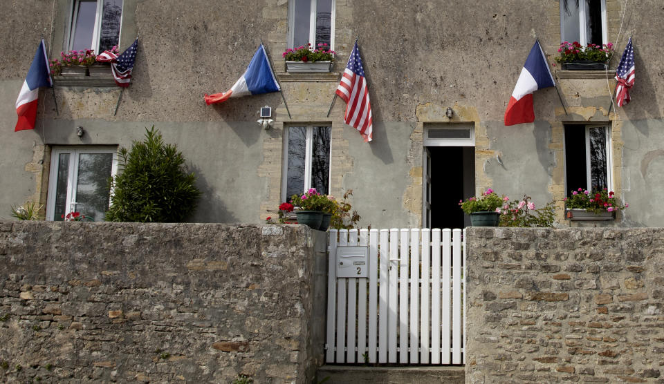 In this photo taken on Thursday, June 4, 2020, French and US flags decorate a house front near Omaha Beach in Saint-Laurent-sur-Mer, Normandy, France. In sharp contrast to the 75th anniversary of D-Day, this year's 76th will be one of the loneliest remembrances ever, as the coronavirus pandemic is keeping nearly everyone from traveling. (AP Photo/Virginia Mayo)