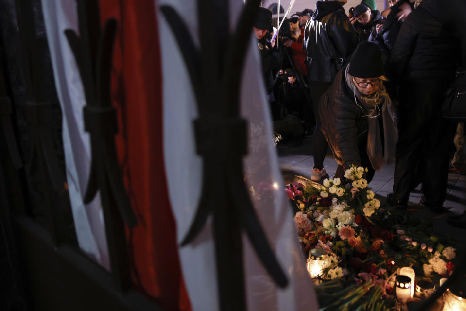 A woman lays flowers during a march in silence to commemorate Lizaveta, a 25-year-old Belarusian woman who died after a being brutally attacked and raped on the streets of Warsaw last month, in Warsaw Poland, Wednesday, March 6, 2024.. The crime has shocked people across Poland. Poles, Belarusians and Ukrainians gathered at the site of the crime in downtown Warsaw, placing flowers and lighting candles in honor of the woman known only as Lizaveta, or Liza. (AP Photo/Michal Dyjuk)