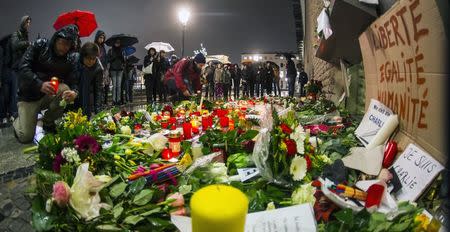 People place flowers of condolences at the French embassy at Pariser Platz in Berlin January 8, 2015. REUTERS/Hannibal Hanschke