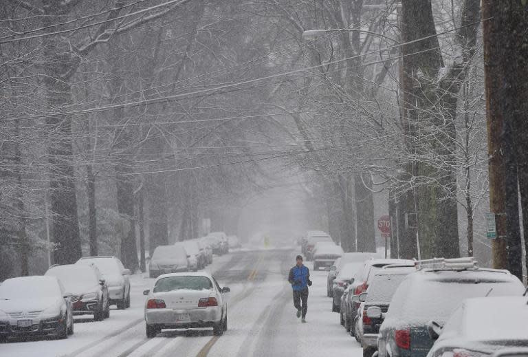 A jogger runs down a residential street under snowfall on March 5, 2015 in Washington, DC