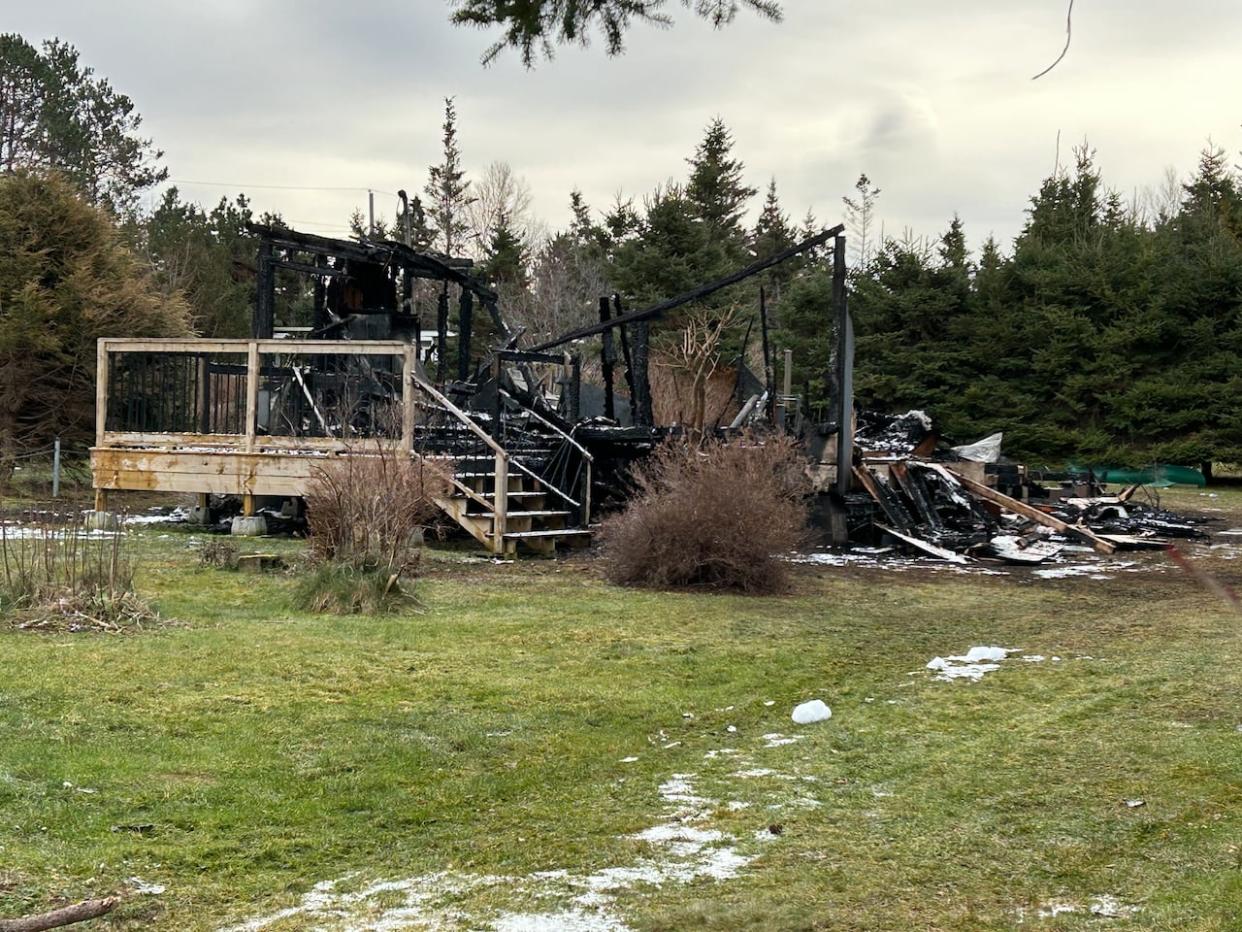 Charred rubble is all that remained from Joanne Cook's cottage on Sunday. (Stacey Janzer/CBC - image credit)