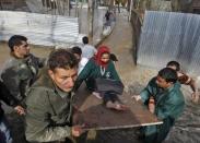 An ailing woman is carried on a wooden plank to a safer place from her partially submerged house after incessant rains in Srinagar March 30, 2015. REUTERS/Danish Ismail