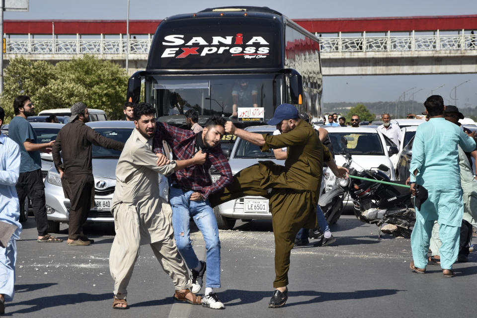 Plainclothes police officers beat a supporter of Pakistan's former Prime Minister Imran Khan as they detain him when he with others blocking a road as protest to condemn the arrest of their leader, in Peshawar, Pakistan, Tuesday, May 9, 2023. Pakistan's anti-graft agents on Tuesday arrested former Prime Minister Khan as he appeared in a court in the capital, Islamabad, to face charges in multiple graft cases, police and officials from his party said. (AP Photo/W.K. Yousufzai)