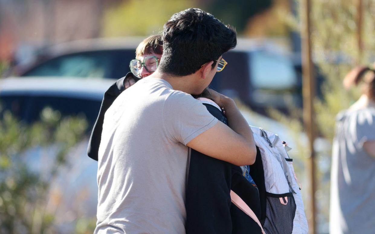 Students console each other after the  shooting incident, the motive for which remains unclear