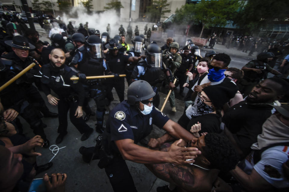 Police officers and protesters clash near CNN Center, May 29, 2020, in Atlanta, in response to George Floyd's death. The protest started peacefully earlier in the day before demonstrators clashed with police. The image was part of a series of photographs by The Associated Press that won the 2021 Pulitzer Prize for breaking news photography. (AP Photo/Mike Stewart)