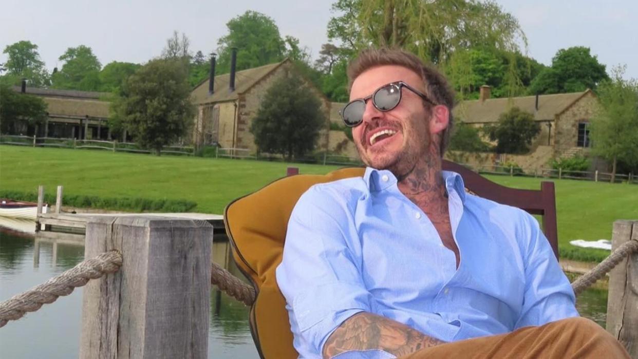 man posing in chair next to lake