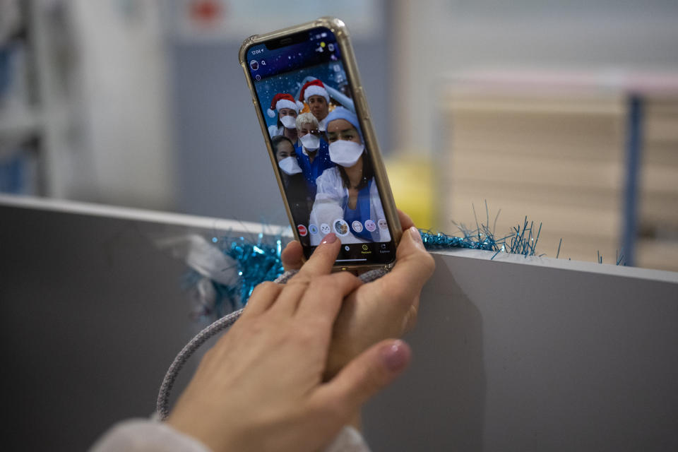 Hospital worker Houda Mokrani takes a selfie with her colleagues on christmas day in the COVID-19 intensive care unit at the la Timone hospital in Marseille, southern France, Friday, Dec. 25, 2021. Marseille’s La Timone Hospital, one of France’s biggest hospitals, has weathered wave after wave of COVID-19. (AP Photo/Daniel Cole)