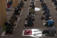 Worshippers at the Cambridge Central Mosque in Cambridge, England, attend the first Friday communal prayers since lockdown on Friday, July 10, 2020. Mats are now spaced apart during communal prayers, and worshippers are asked to bring their own. Attendees' names and phone numbers were collected for possible contact tracing purposes. (AP Photo/Elizabeth Dalziel)