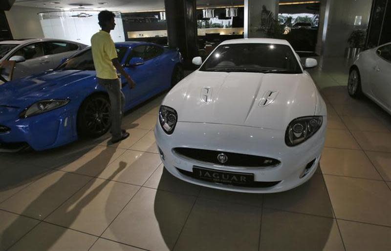 A showroom attendant walks past a Jaguar car at a Jaguar Land Rover showroom in Mumbai February 13, 2013. REUTERS/Vivek Prakash/Files