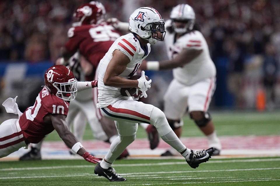 Arizona wide receiver Tetairoa McMillan (4) catches a pass in front of Oklahoma linebacker Kip Lewis (10) during the first half of the Alamo Bowl NCAA college football game in San Antonio, Thursday, Dec. 28, 2023. (AP Photo/Eric Gay)