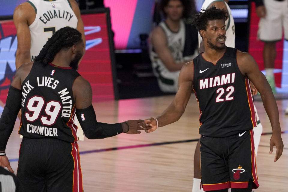 Miami Heat's Jae Crowder (99) and Jimmy Butler (22) celebrate their 104-115 win against the Milwaukee Bucks during an NBA basketball conference semifinal playoff game, Monday, Aug. 31, 2020, in Lake Buena Vista, Fla. (AP Photo/Mark J. Terrill)