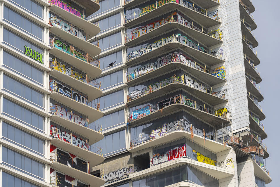 Windows are tagged with graffiti as seen on the balconies of an unfinished high-rise tower after the developer ran out of money, have become an embarrassment in a high-profile area that includes the Crypto.com Arena, home of major sports teams and events, Friday, Feb. 16, 2024 in Los Angeles. (AP Photo/Damian Dovarganes)