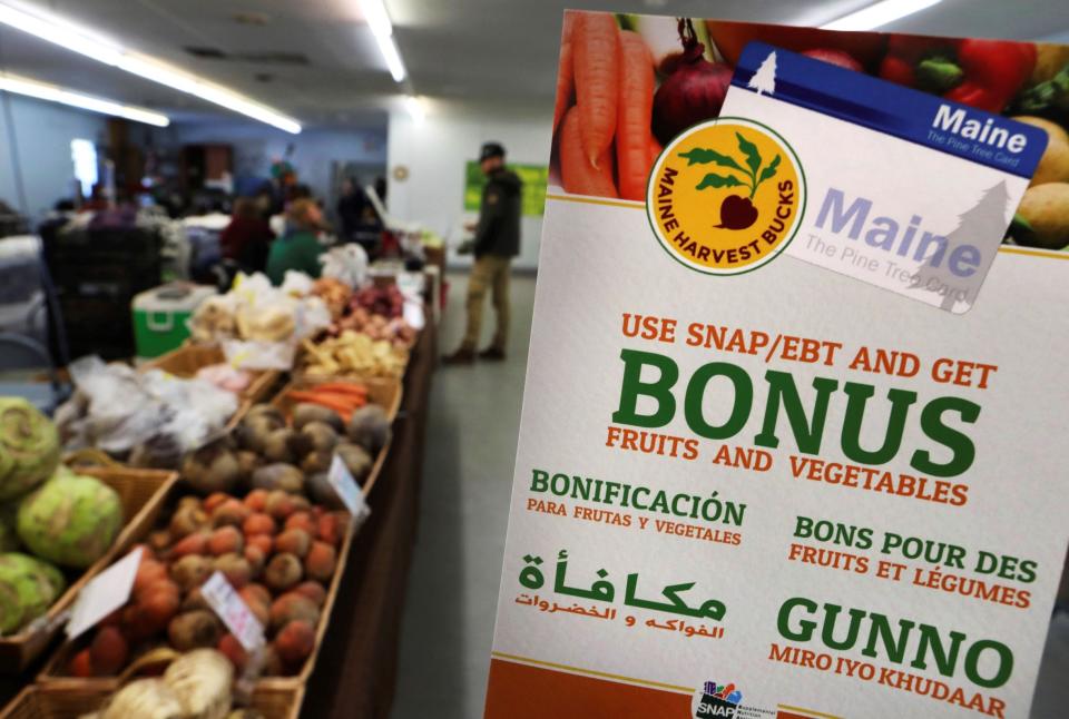 In this Friday, March 17, 2017, file photo, a sign advertises a program that allows food stamp recipients to use their EBT cards to shop at a farmer's market in Topsham, Maine. While many supermarkets and discounters accept SNAP benefits, many do not offer online grocery services amid the pandemic.