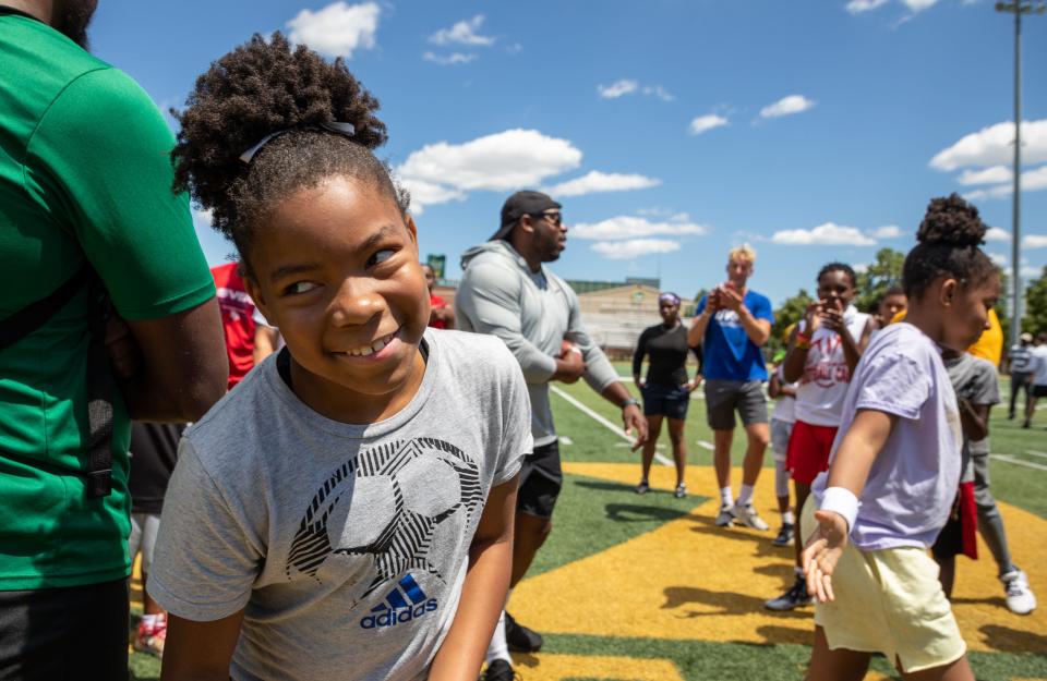 Jamiee Robertson goes back to her team after losing rock, paper scissors against her twin sister Jo'elle Robertson during a youth football clinic at Wayne State University in Detroit on Monday, July 25, 2022.