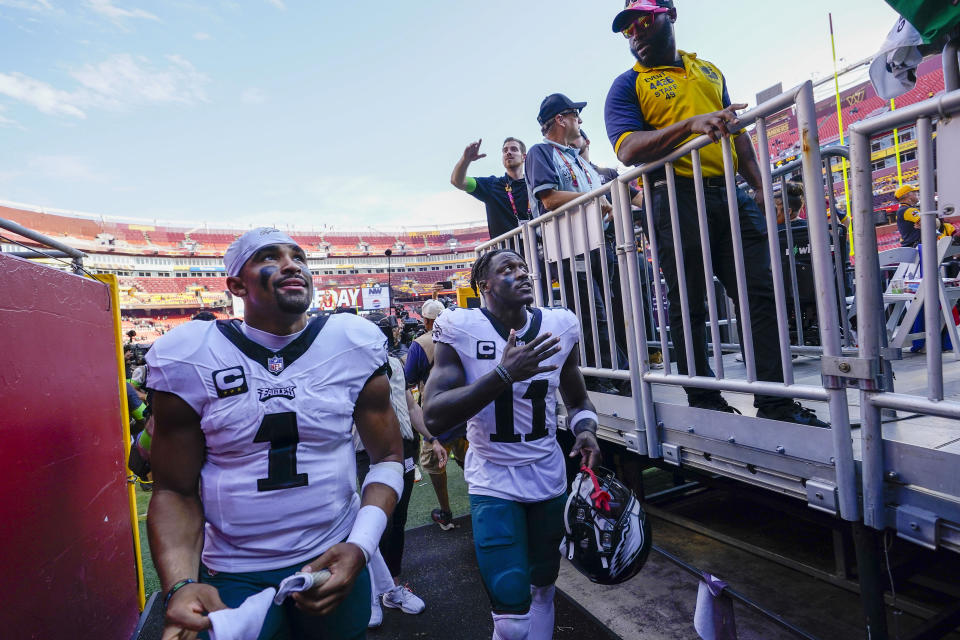 Philadelphia Eagles quarterback Jalen Hurts (1) and wide receiver A.J. Brown (11) looking up to fans as they head back to the locker room at the end of an NFL football game against the Washington Commanders, Sunday, Oct. 29, 2023, in Landover, Md. Eagles won 38-31. (AP Photo/Alex Brandon)