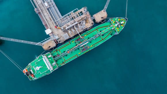 An overhead view of an LNG shipping vessel being loaded at an export terminal.