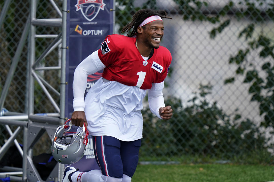 New England Patriots quarterback Cam Newton smiles as he steps on the field at the start of practice. (AP Photo/Steven Senne, Pool)