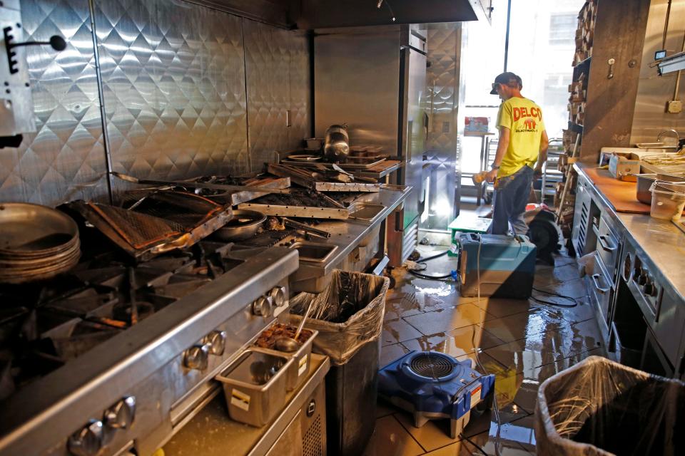 Workers assess the damage from a fire on Wednesday inside Broadway 10 in Oklahoma City.