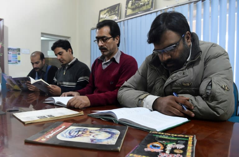 Pakistani men read Hindko language books at The Hindko Centre in Peshawar
