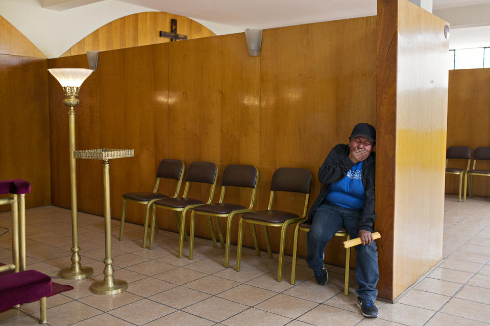 <p>Evila cries in the corner of the funeral home where people prepare Tamara’s body for viewing. (Photo: Danielle Villasana) </p>