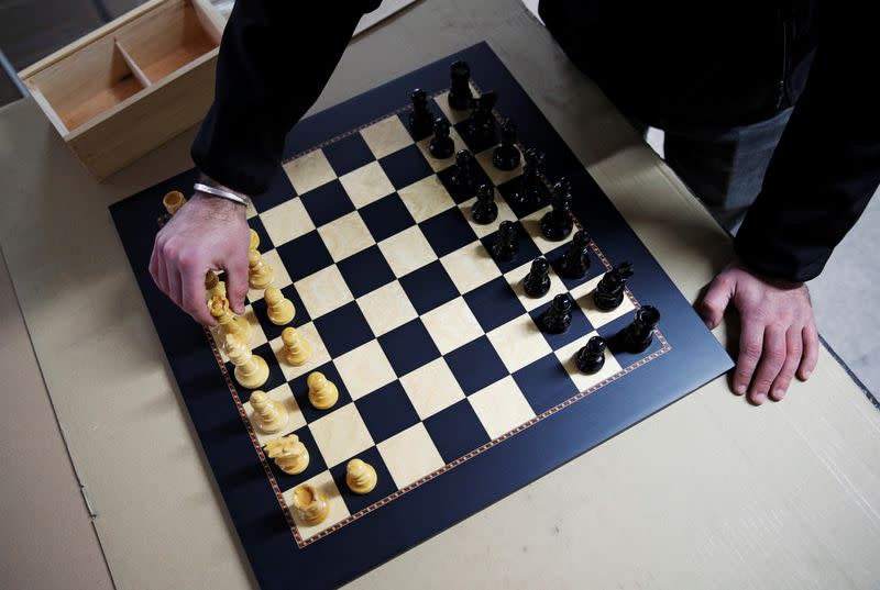 David Ferrer moves a chess piece on a chessboard at the Rechapados Ferrer factory in La Garriga