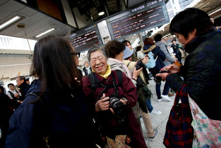 Royal aficionado Fumiko Shirataki, 78, and her friends react after taking photographs of Japan's Emperor Akihito and Empress Michiko at Tokyo Station in Tokyo, Japan, March 25, 2019. REUTERS/Issei Kato