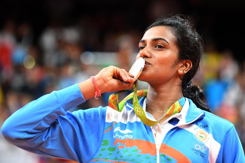 Silver medalist India's Pusarla V Sindhu celebrates on the podium following the women's singles Gold Medal badminton match at the Riocentro stadium in Rio de Janeiro on 19 August 2016, for the Rio 2016 Olympic Games (AFP via Getty Images)