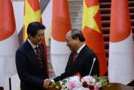 Japan's Prime Minister Shinzo Abe (L) shakes hands with his Vietnamese counterpart Nguyen Xuan Phuc after they attended a joint press briefing at Phuc's Cabinet Office in Hanoi, Vietnam January 16, 2017. REUTERS/Hoang Dinh Nam/Pool