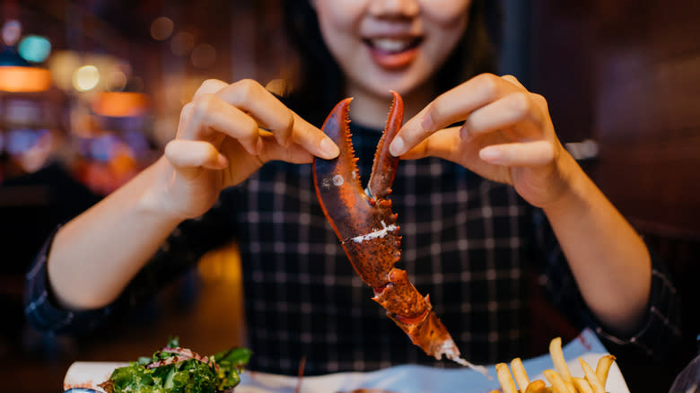 Woman eating a lobster claw