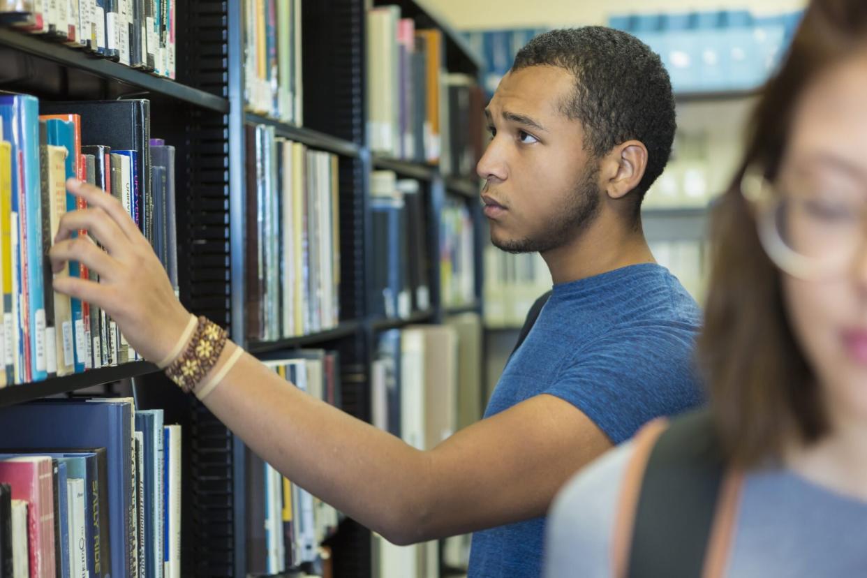 boy choosing book in library