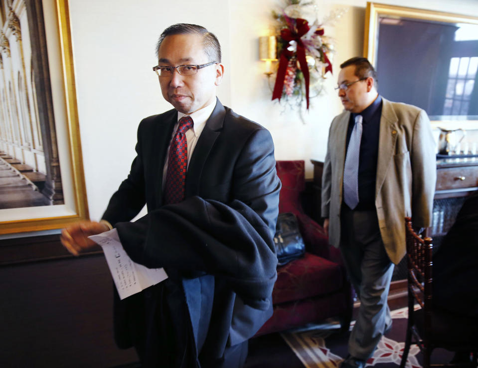 Cranston, R.I., Mayor Allan Fung, left, leaves a news conference after speaking with reporters at the Chapel Grill in Cranston, Monday, Jan. 13, 2014. Fung, a leading Republican candidate for Rhode Island governor disclosed on Monday that he was responsible for a crash that killed a man 25 years ago. (AP Photo/Michael Dwyer)