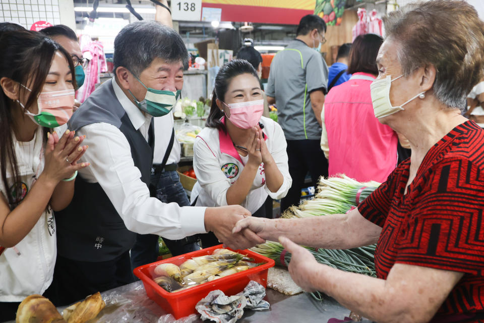 民進黨台北市長參選人陳時中（前左2）15日在台北市議員參選人等人陪同下，到萬華區西寧市場拜票，與攤商話家常。（中央社）