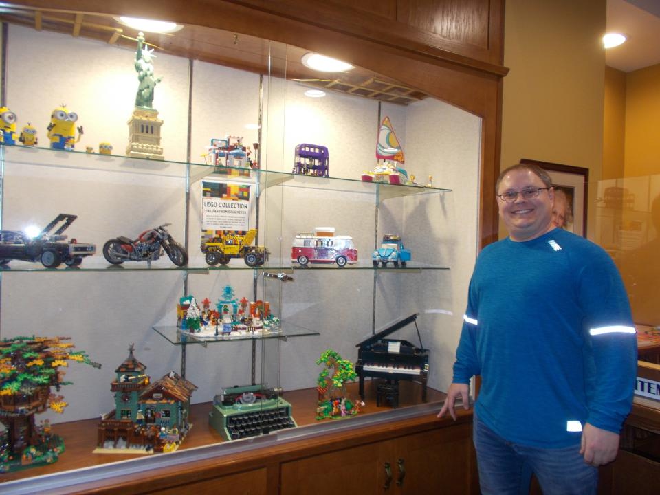 Doug Meyer stands at the Clyde Public Library with a display of his Lego projects.