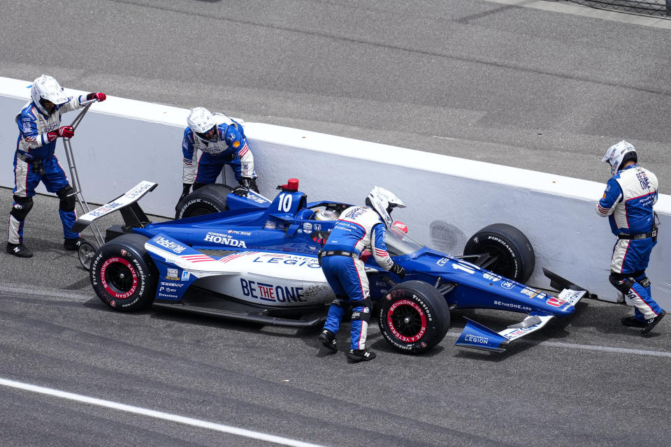 The crew of Alex Palou, of Spain, rushes to his aid after his was hit in the pit area during the Indianapolis 500 auto race at Indianapolis Motor Speedway in Indianapolis, Sunday, May 28, 2023. (AP Photo/AJ Mast)