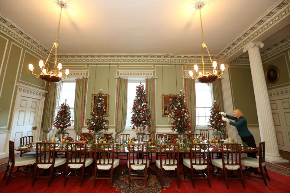 EDITORIAL USE ONLY Deborah Clarke puts the finishing touches to the Christmas display in the Dining Room of the Palace of Holyroodhouse in Edinburgh, Scotland.