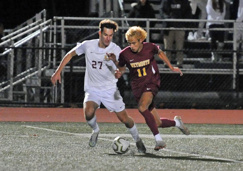 BC High's Elias Novina, left, and Bruno DeSouza, right, battle for the ball during boys soccer Division 1 playoffs at Weymouth High School, Wednesday, Nov. 9, 2022. Both players scored with DeSouza notching the OT winner.