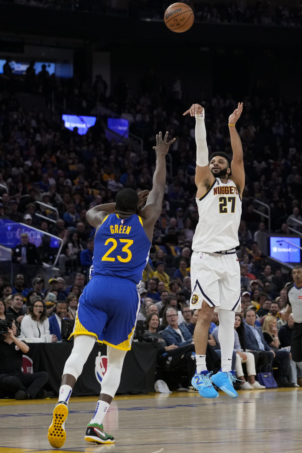 Denver Nuggets guard Jamal Murray (27), right, shoots a 3-point basket in front of Golden State Warriors center Draymond Green (23) during the first half of an NBA basketball game, Sunday, Feb. 25, 2024, in San Francisco. (AP Photo/Godofredo A. Vásquez)