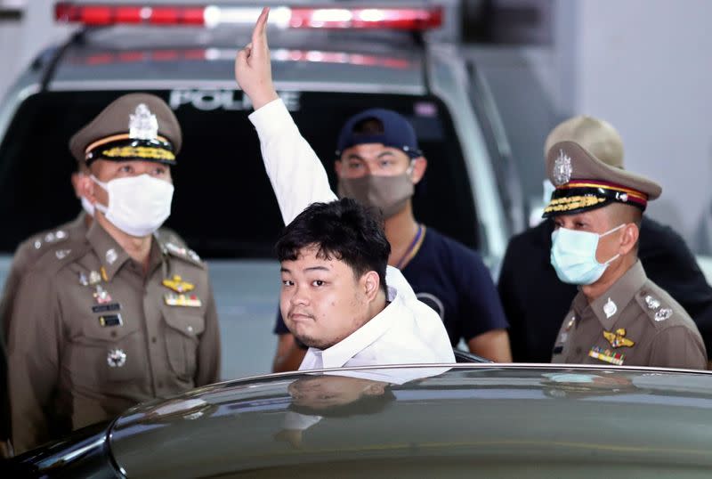 Parit Chiwarak is escorted after being arrested at the police station in Bangkok