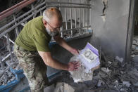 A Ukrainian serviceman searches through the rubble of a school that was destroyed some days ago during a missile strike in outskirts of Kharkiv, Ukraine, Tuesday, July, 5, 2022. (AP Photo/Andrii Marienko)