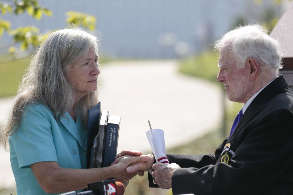 Wendy Walton Reichenbach, left, shakes hands with Tom Beck, right, of the Military Order of the Purple Heart, after a wreath-laying ceremony at the National Veterans Memorial and Museum.