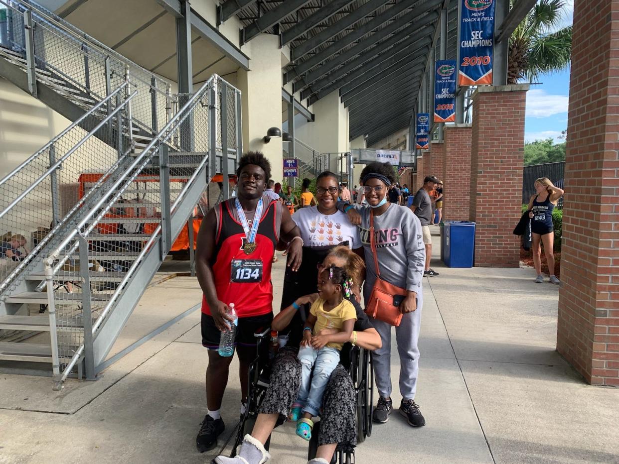 Dunnellon’s Winston Sanders, left, wears his track medal on the UF campus, host of the FHSAA state track finals.