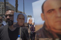 Angry demonstrators carry pictures of Nizar Banat, an outspoken critic of the Palestinian Authority, and chant anti-PA slogans during a rally protesting his death, in the West Bank city of Ramallah, Thursday, June 24, 2021. Banat who was a candidate in parliamentary elections called off earlier this year died after Palestinian security forces arrested him and beat him with batons on Thursday, his family said. (AP Photo/Nasser Nasser)