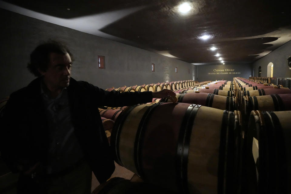 Laurent Lebrun, director of the Château Olivier Grand Cru Classe de Graves estate, shows barrels of red wine in the cellar, in Leognan, south of Bordeaux, southwestern France, Monday, Aug. 22, 2022. The harvest that once started in mid-September is now happening earlier than ever in one of France’s most celebrated wine regions and other parts of Europe due to drought and climate change. (AP Photo/Francois Mori)