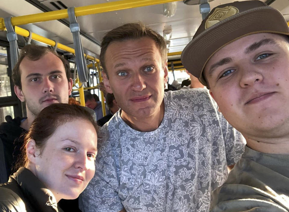 FILE - In this Aug. 20, 2020, file photo taken and provided by gluchinskiy, Russian opposition leader Alexei Navalny, center, and Kira Yarmysh, foreground left, pose inside a bus on their way to an airport outside Tomsk, Russia. Attempts over the years to silence Navalny have all failed so far. Now the Kremlin critic is in a coma in a Berlin hospital after suffering what German authorities say was a poisoning with a chemical nerve agent while traveling in Siberia on Aug. 20. (gluchinskiy via AP, File)