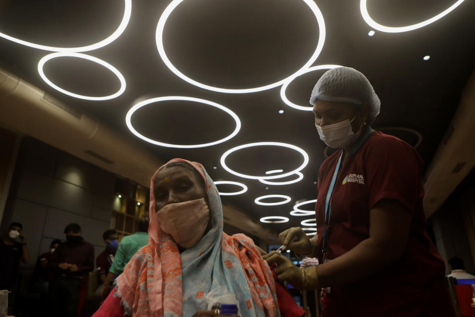 A health worker inoculates a woman against COVID-19 at vaccination center set up inside a shopping mall that remains closed to business in Mumbai, India, Wednesday, Aug. 11, 2021. (AP Photo/Rajanish Kakade)