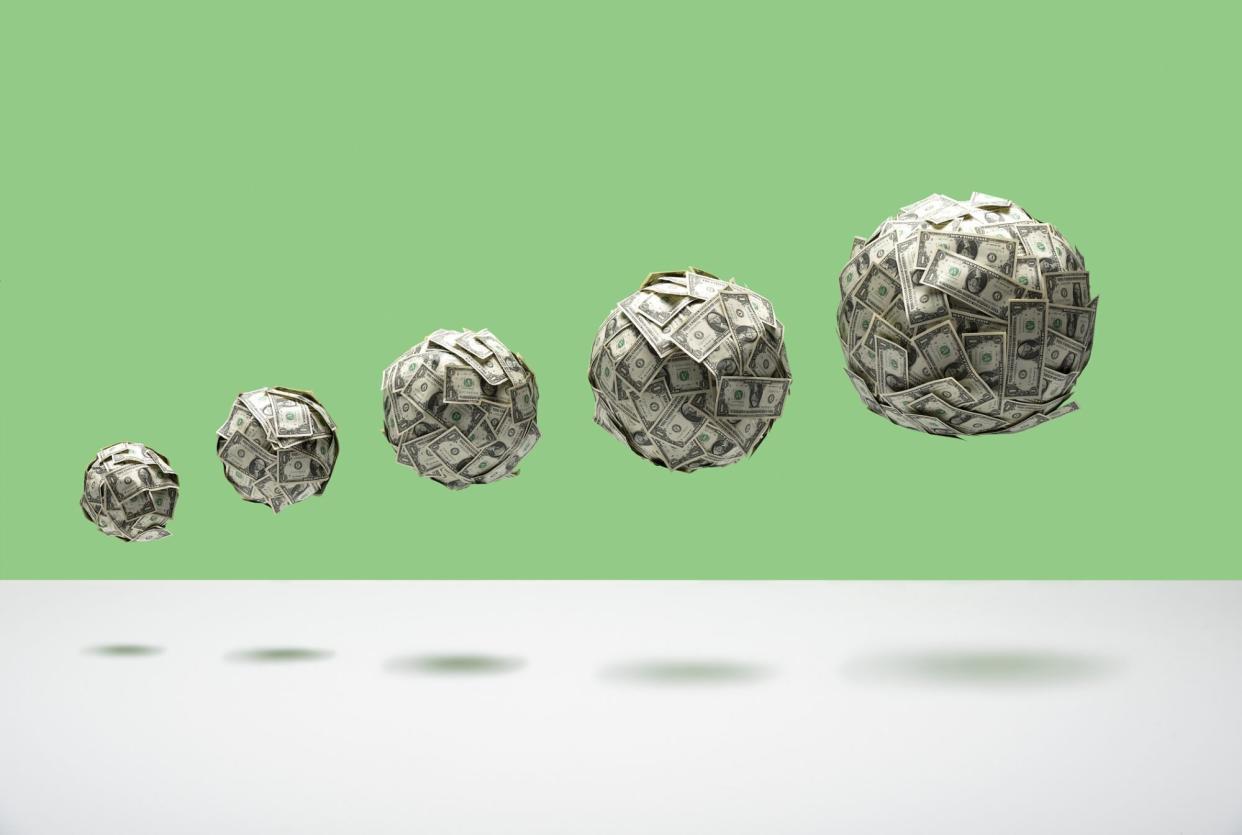 An image of growing balls of money floating in mid air.