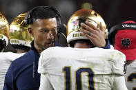 Notre Dame head coach Marcus Freeman, left, talks to quarterback Drew Pyne after they scored a touchdown during the first half of an NCAA college football game against Southern California Saturday, Nov. 26, 2022, in Los Angeles. (AP Photo/Mark J. Terrill)