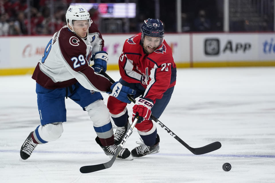 Colorado Avalanche center Nathan MacKinnon (29) and Washington Capitals left wing Conor Sheary (73) compete for the puck during the second period of an NHL hockey game Tuesday, Oct. 19, 2021, in Washington. (AP Photo/Alex Brandon)