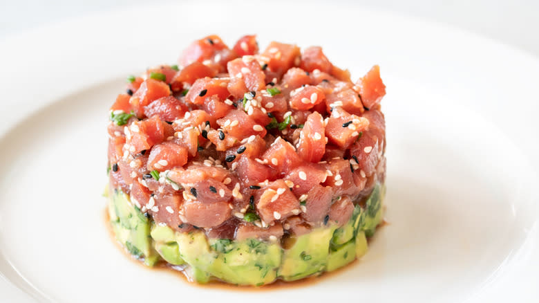 tuna tartare with a layer of avocado on a plate up close
