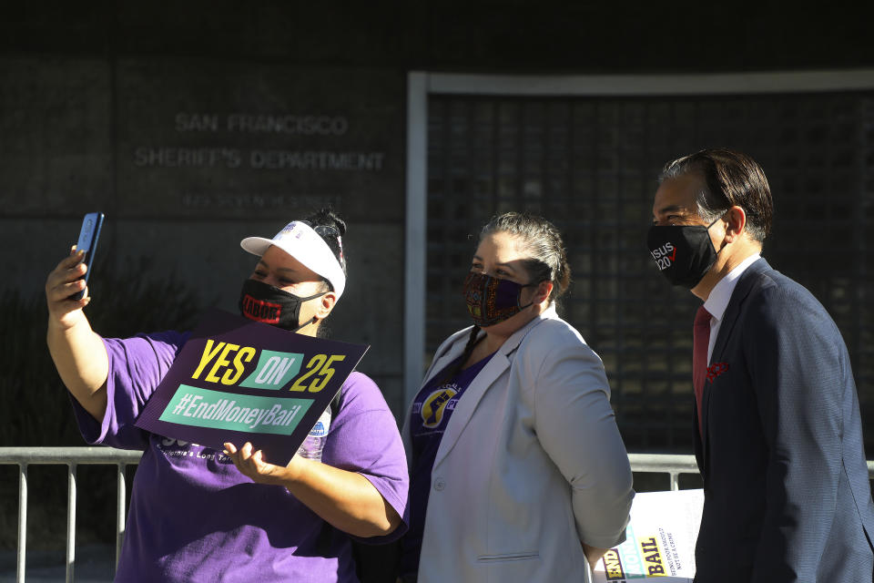 Aminta Alvarado, left, Mullissa Willette, center, and Assembly member Rob Bonta, right, pose for a photo before a rally for "Yes on 25", a ballot proposition to eliminate the cash bail system in the state on Oct. 13, 2020, in San Francisco. California Gov. Gavin Newsom has nominated Rob Bonta to be the state's next attorney general. (Aric Crabb/Bay Area News Group via AP)